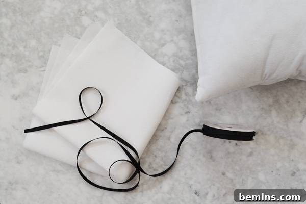 Stylish Geometric Pillows Easy DIY Guide 6 Essential sewing supplies for crafting geometric pillows: fabric, ribbon, and a pillow insert, laid out on a clean surface.