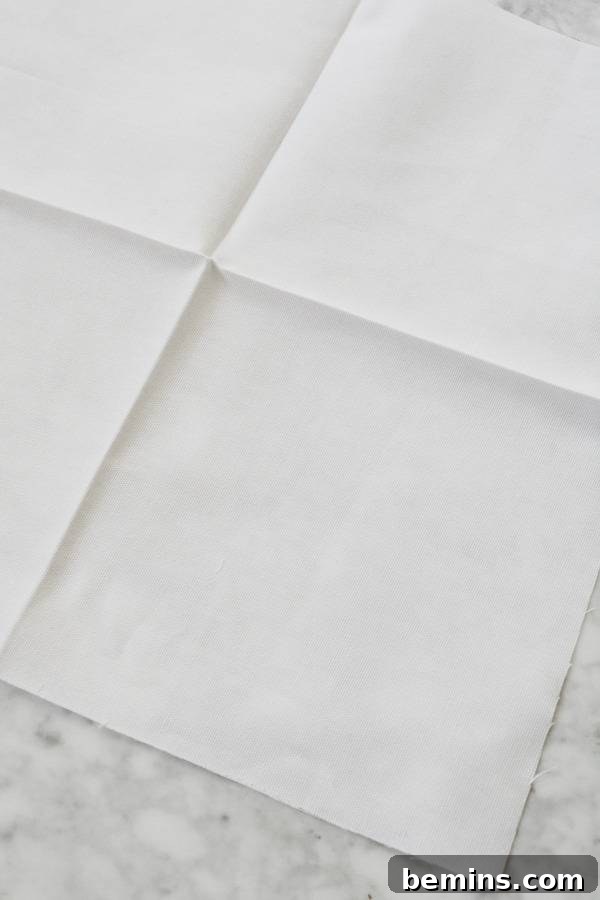 Stylish Geometric Pillows Easy DIY Guide 8 A fabric square carefully folded and ironed twice, revealing crisp creases that will serve as guides for the geometric pattern.