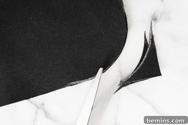 A person is cutting cloth edges in curve shape with scissor.