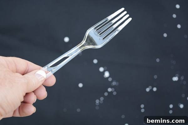 A person is holding a fork in his hand.