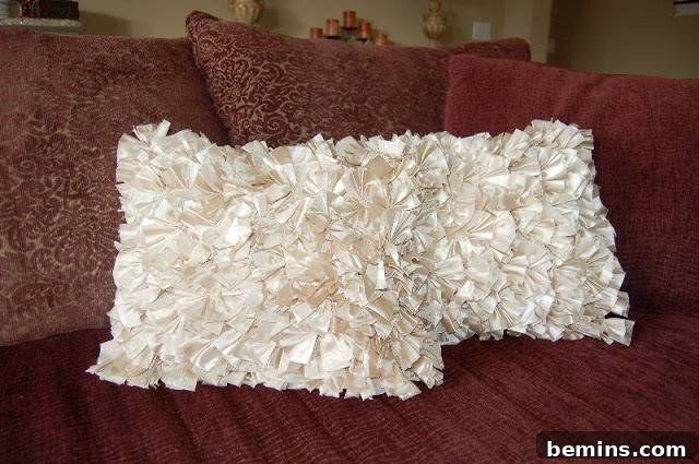 Two white pillows sit on a red bed with three red pillows behind them.