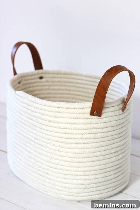 White laundry basket with brown handles.