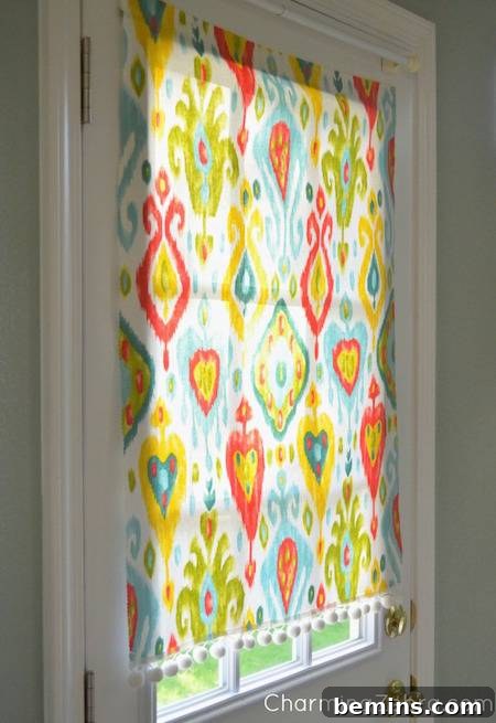Kitchen entryway window cover with colorful designs of various shapes and sizes.