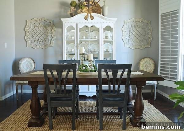 A white sideboard filled with white dishes, paired with a brown table and blue chairs in a beautifully coordinated dining room.