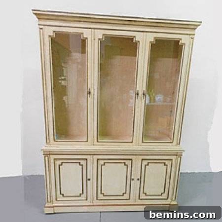 An old white cabinet exuding vintage charm against a wall.