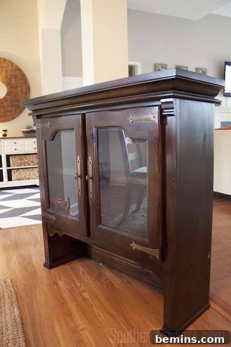 A glass-doored, dark wood hutch standing elegantly on a hardwood floor.