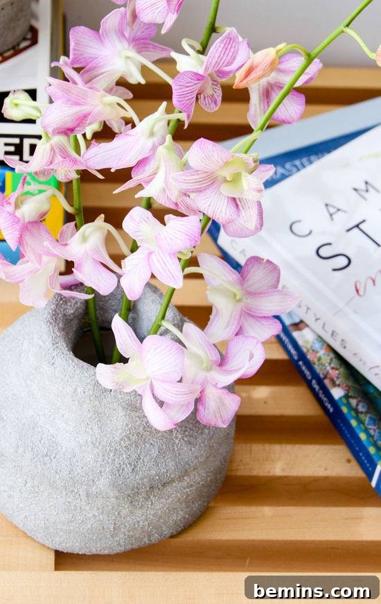 Floral pot with books aside on the table.
