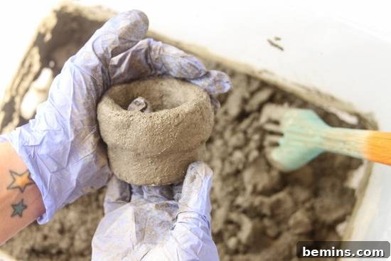 A person is making pot using mud.