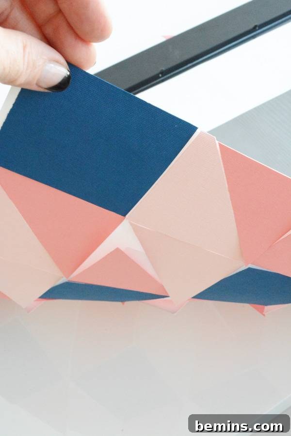 A person is moving a material in pink and blue colors.