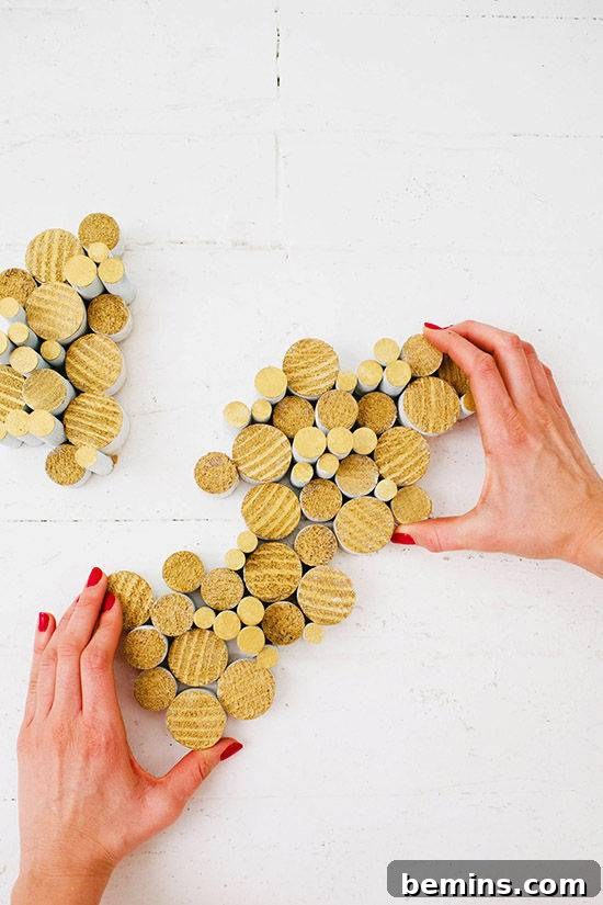 Hands surround an abstract grouping of wooden disks of varying sizes