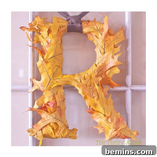 A decorative letter 'R' adorned with colorful faux leaves, creating a festive fall accent.