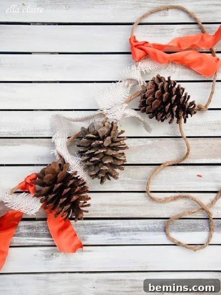 A pinecone garland adorned with orange ribbons, strung across a mantel as a festive fall decoration.