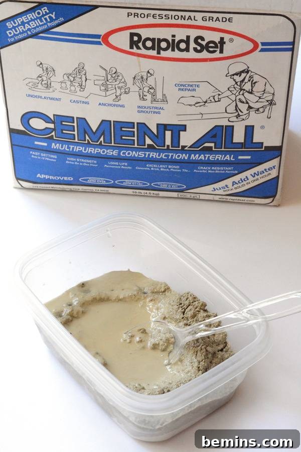 A hand mixing concrete for garden art in a plastic container, ensuring a smooth, milkshake-like consistency.