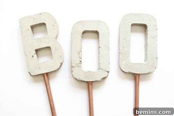 The word Boo, formed by three concrete letters individually mounted on copper sticks, adds a unique touch to garden decor.