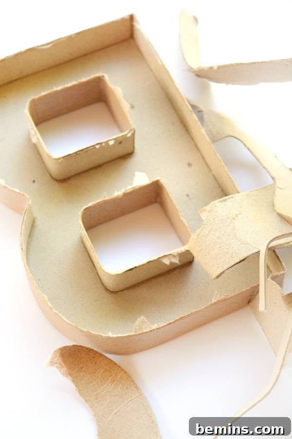 The letter B made out of cardboard, with its back carefully removed to create an open mold for cement.