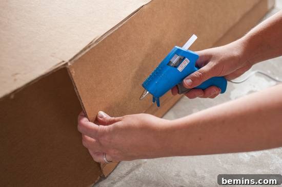 Using a hot glue gun to assemble the cardboard popsicle
