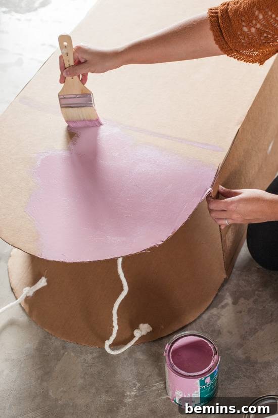 Painting the cardboard popsicle costume pink