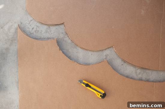 Craft Your Own Bird Costume: A Step-by-Step Guide 6 A piece of cardboard has been cut in half in a scallop shape, the blade still sitting on the bottom piece.