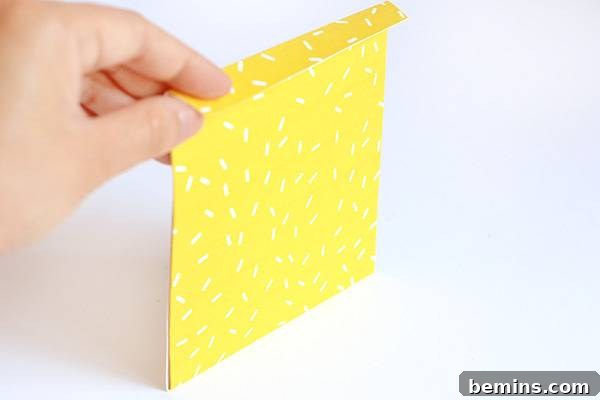 Folding the top tab of the Halloween fang treat bag