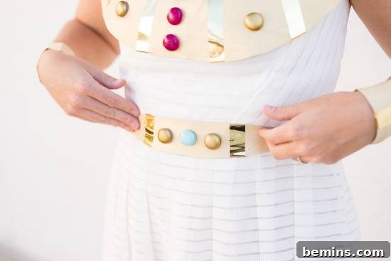 A girl wearing a Cleopatra Halloween Costume and she touch her belt.
