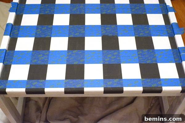 Black and white striped table with blue tape striped across it.