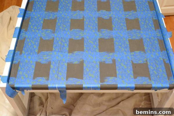 A dark table has blue tape hanging from it.