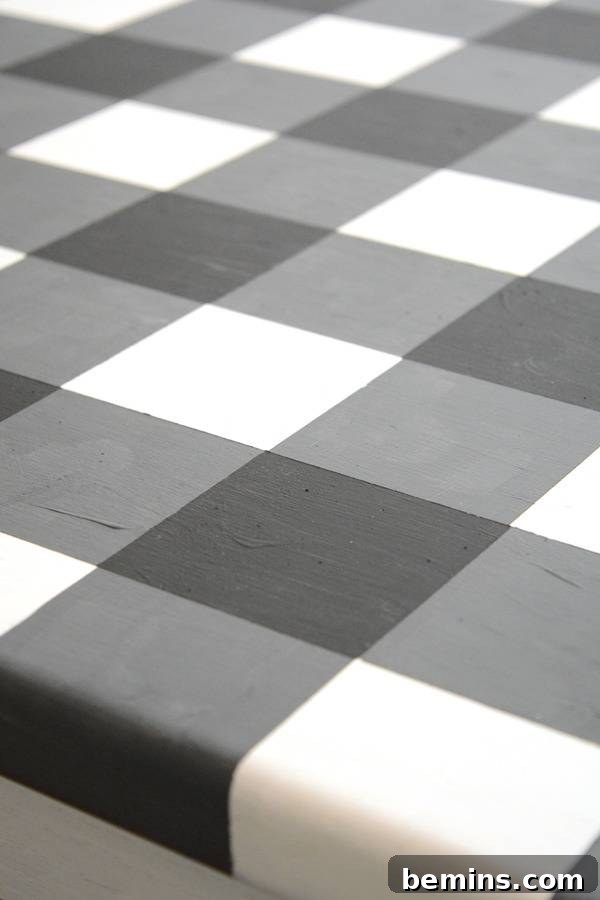 Black, grey and white coloured square type pattern on a bed sheet.