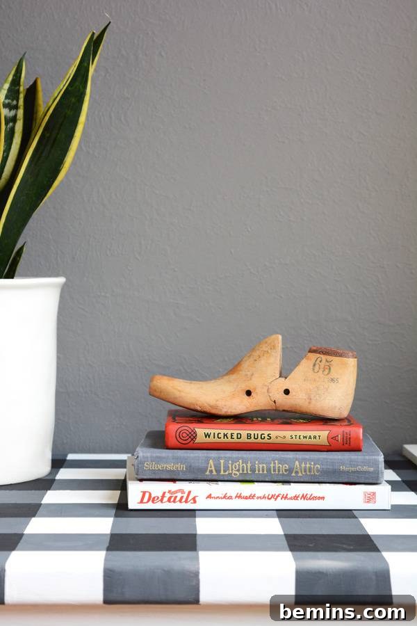 A shoe set up on three books on a table.