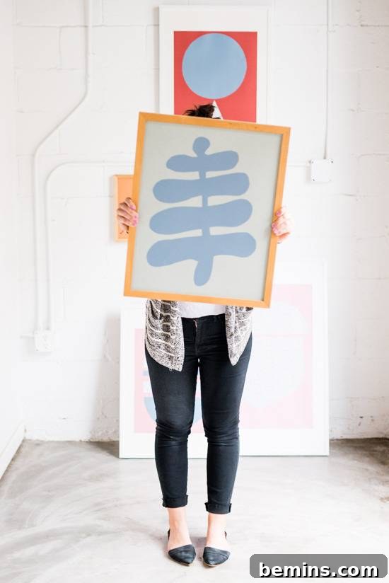 Craft Quick Wall Art: A 30-Minute DIY Project 14 A person is holding up a blue and white picture with a yellow frame.
