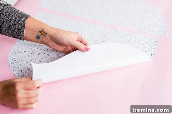 Craft Quick Wall Art: A 30-Minute DIY Project 8 A person pulling a white paper from a pink surface.