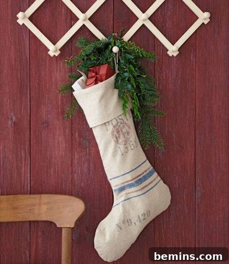 A Christmas stocking with holly hanging on a red wall from an accordion rack.