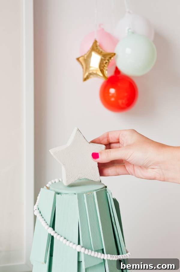 Adding a star to a homemade Christmas tree.