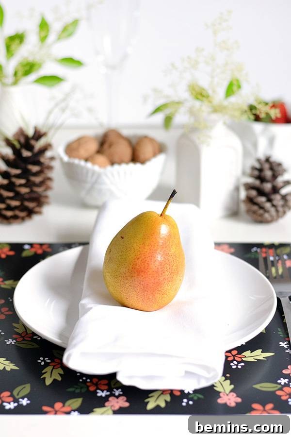 A close-up of a pear elegantly displayed on a plate, showcasing a simple yet sophisticated table setting.