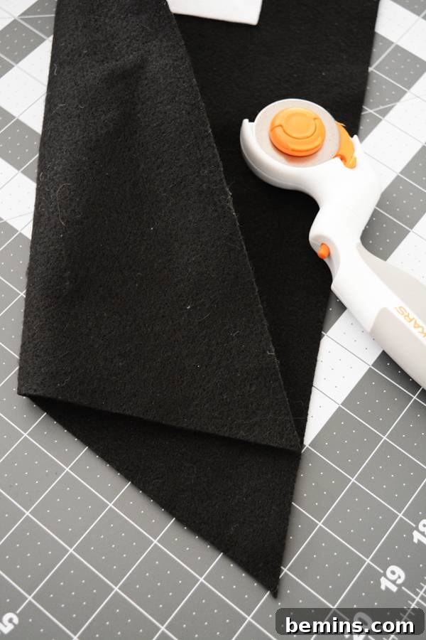 Black wool cloth being cut to create the V-shape at the bottom of the banner.
