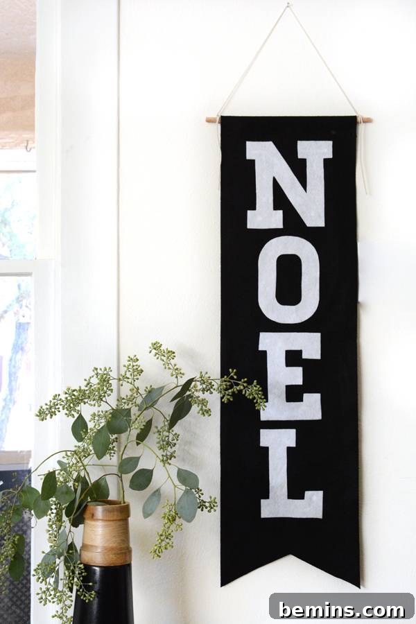 The finished NOEL banner hanging on a wall, showcasing its festive appeal.