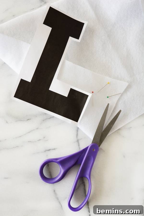 The letter 'L' template placed on felt, ready for cutting.