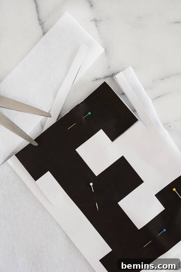 A black 'E' ready for sewing onto a banner, showcasing the cut letter.