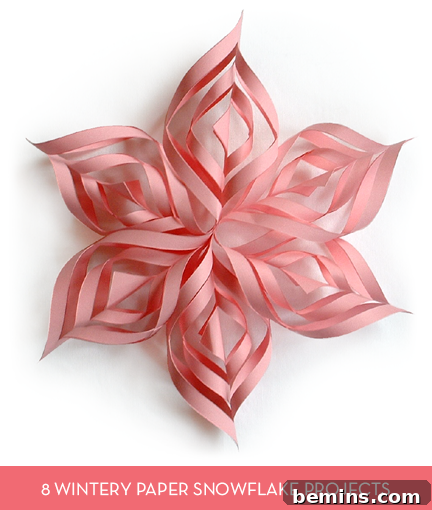 A delicately crafted pink paper snowflake, showcasing intricate designs.