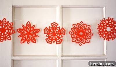 A string of vibrant red paper snowflakes, adding a pop of color to any space.