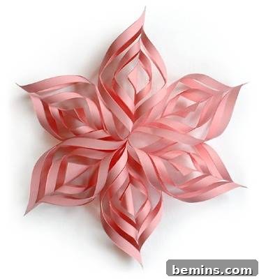 A stunning 3D paper snowflake, resembling a delicate pink flower.