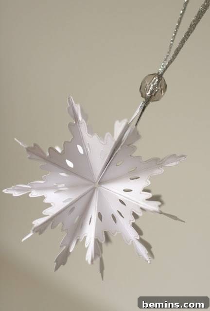 An elegant paper snowflake ornament, gracefully hanging from the ceiling.