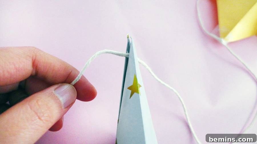 Attaching the origami star to a string for the garland