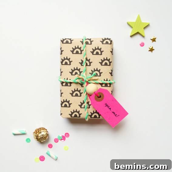 A small gift box charmingly wrapped in playful brown paper adorned with a unique eye pattern, secured with a vibrant green string, showcasing a distinctive and fun presentation.