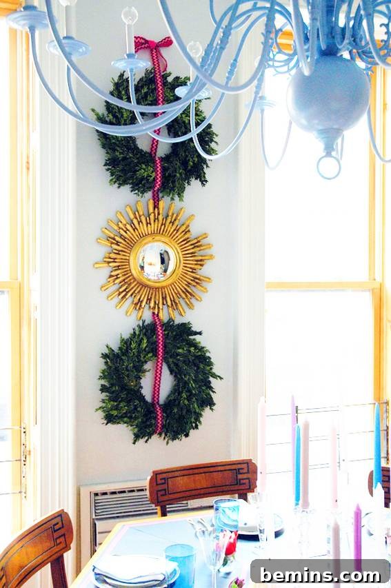 Banisters and wreaths hanging on a wall behind a dining room table, demonstrating how to incorporate existing decor into your Christmas decorations.