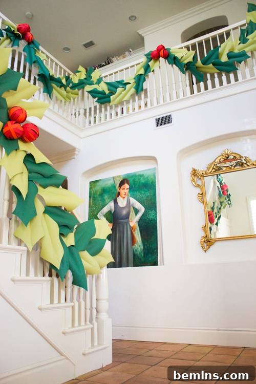A banister decorated with an oversized berry paper garland, adding a modern and colorful touch to traditional Christmas decor.