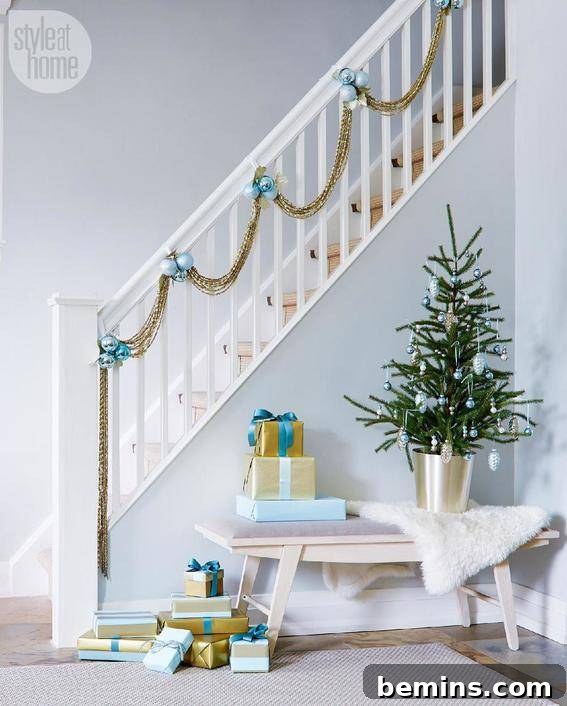 A white house with stairs decorated with blue ornaments and gold beading, offering a unique and elegant Christmas theme.