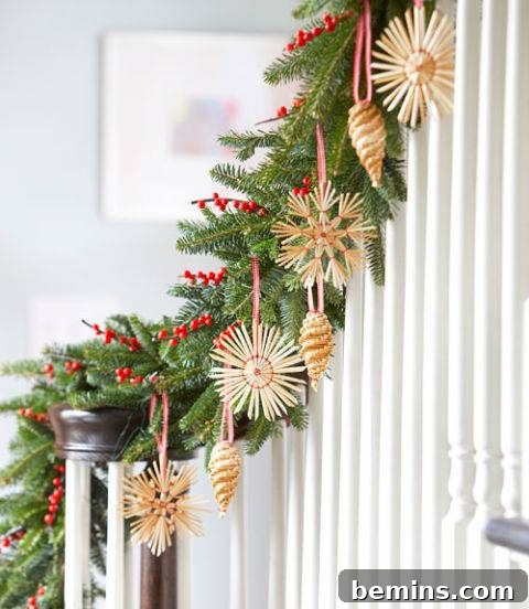 A bannister decorated with Scandinavian-inspired Christmas greenery, featuring simple red berries and minimalist ornaments.
