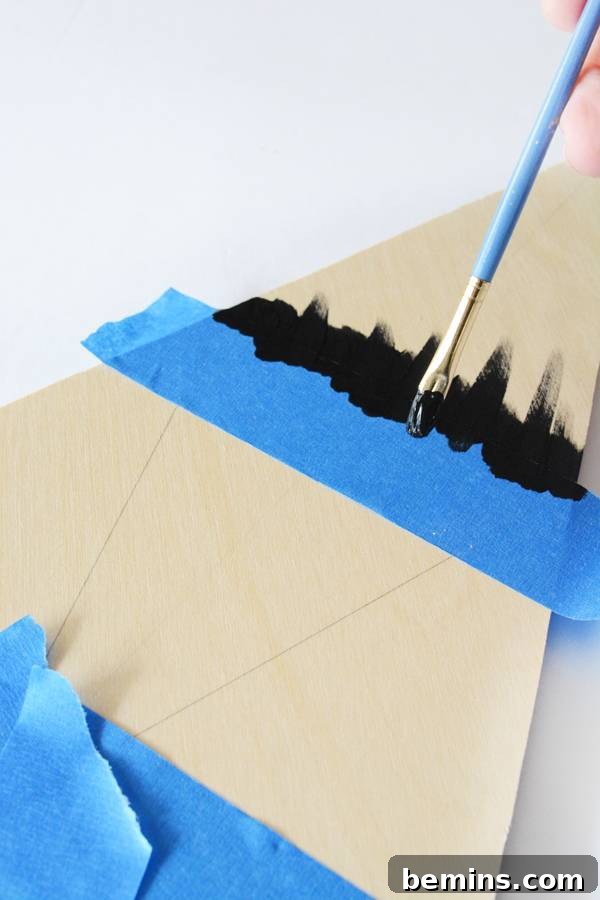 Painting the center of the triangle and removing the tape, showcasing the painting technique.