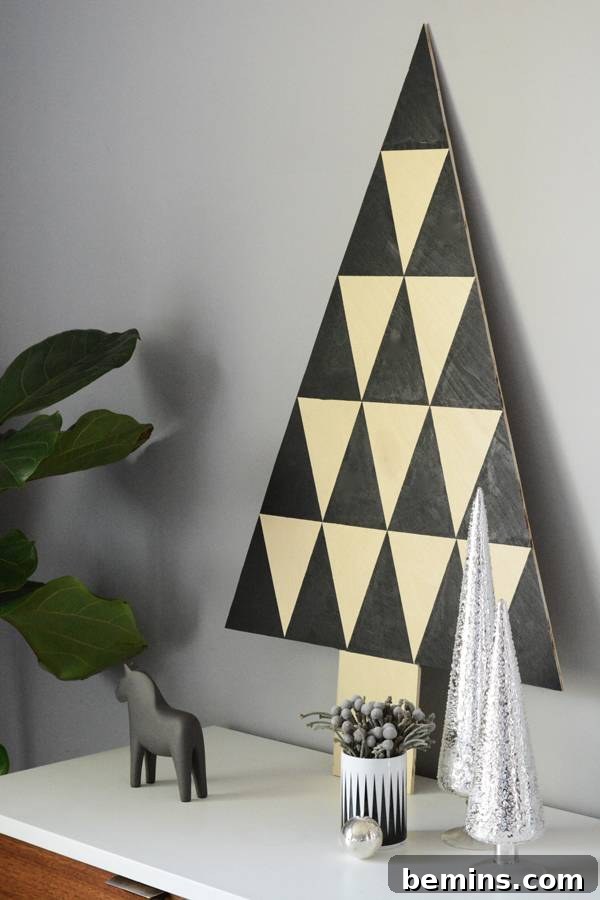 Black and white triangle shaped wall decoration hanging on a silver painted wall.