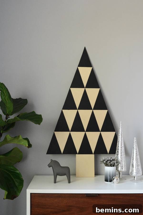 Wooden Christmas tree and Christmas decorations on a white table, creating a festive scene.